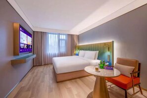 A hotel room with a bed, a round table with chairs, a TV mounted on the wall, and a window with curtains. - Manxin Hotel Changsha IFS (Changsha)