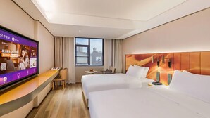 A hotel room with two beds, a TV, a desk, and a window with a view. - Manxin Hotel Changsha IFS (Changsha)