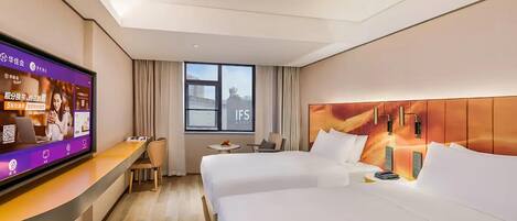 Une chambre d’hôtel avec deux lits, une télévision, un bureau et une fenêtre donnant sur un paysage agréable.