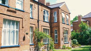 A brick building with multiple windows and a garden area. - The Gregory by Warren Collection (Belfast)