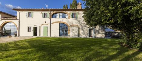 A two-story building with a symmetrical facade, large arched windows, and a well-maintained lawn.