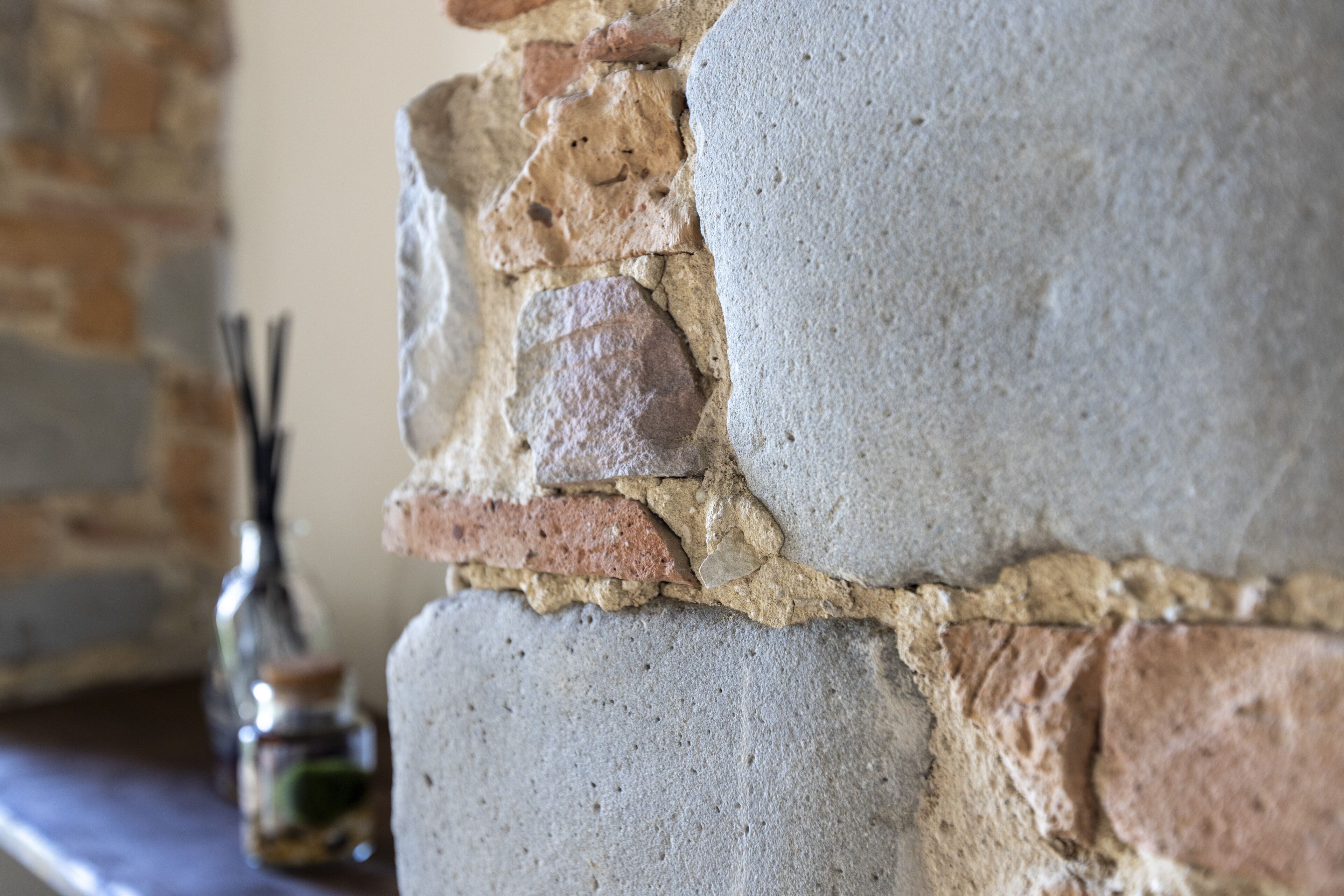 A close-up of a stone wall with a mix of rough and smooth textures.