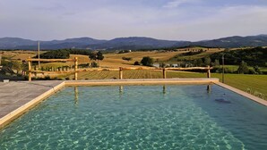 A clear pool with a view of distant mountains and fields.