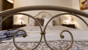 A bed with a metal headboard, a patterned bedspread, and two bedside lamps.