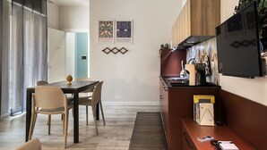 Une cuisine moderne avec des meubles en bois, un four encastré et un téléviseur à écran plat.