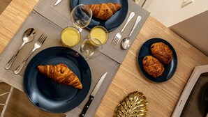 A breakfast setting with croissants, juice, and a knife on a table. - Havre de Paix  Jacuzzi (Asnieres-sur-Seine)