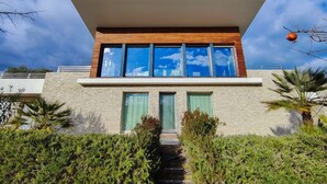 A modern house with a flat roof, large windows, and a stone facade. - [Luxury & Relaxation] Private Pool with View (Civitanova MARCHE)