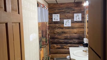 Een douche, een bidet, handdoeken, toiletpapier