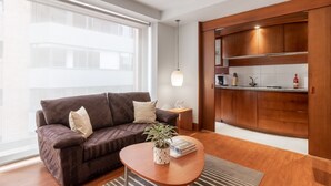 Un salon moderne avec un canapé marron, une table basse en bois et une plante en pot.