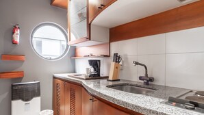 Une cuisine dotée d’un plan de travail en granit, d’un évier en acier inoxydable et de meubles en bois.