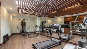Une salle de sport moderne équipée de machines de cardio, d’appareils de musculation et dotée d’un plafond en bois.