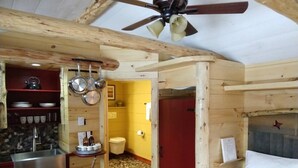 Quarto compacto com cozinha compacta, uma cama e um banheiro.