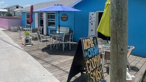 A blue building with outdoor seating and a sign reading "HOME of the ORIGINAL GOMBAY SMASH". - The Green Grouper, oversized beach villa. (Central Abaco , Treasure Cay)