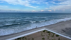 Ein Strand mit weißer Brüstung, Wellen und blauem Himmel.