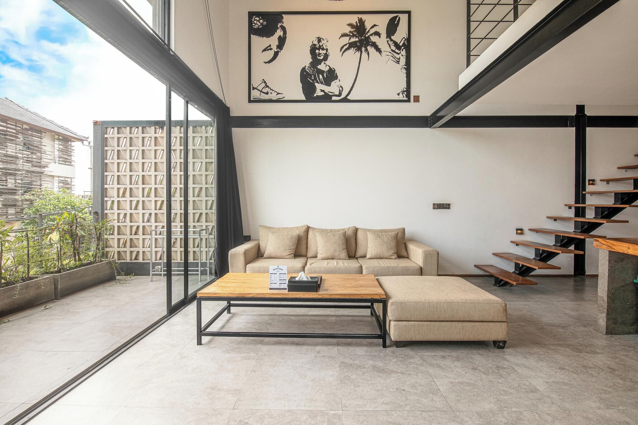 A modern living room with a sofa, a coffee table, and a staircase.