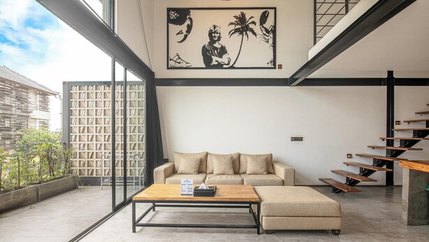 Una sala de estar moderna con un sofá, una mesa de centro y una escalera.