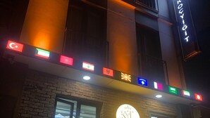 Un bâtiment sur lequel on peut lire l’inscription « KOCAYIGIT » et qui est orné de plusieurs drapeaux illuminés.