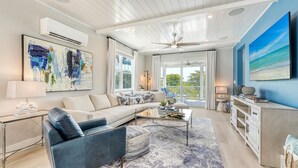A spacious living room with a large sectional sofa, a coffee table, and a TV on a stand. - Saltwater Serenity | Canal Front w/ Heated Pool Near Anna Maria Island (Cortez)