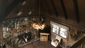 Ein rustikales Interieur mit Holzbalken, Steinwänden und Hirschgeweihen.