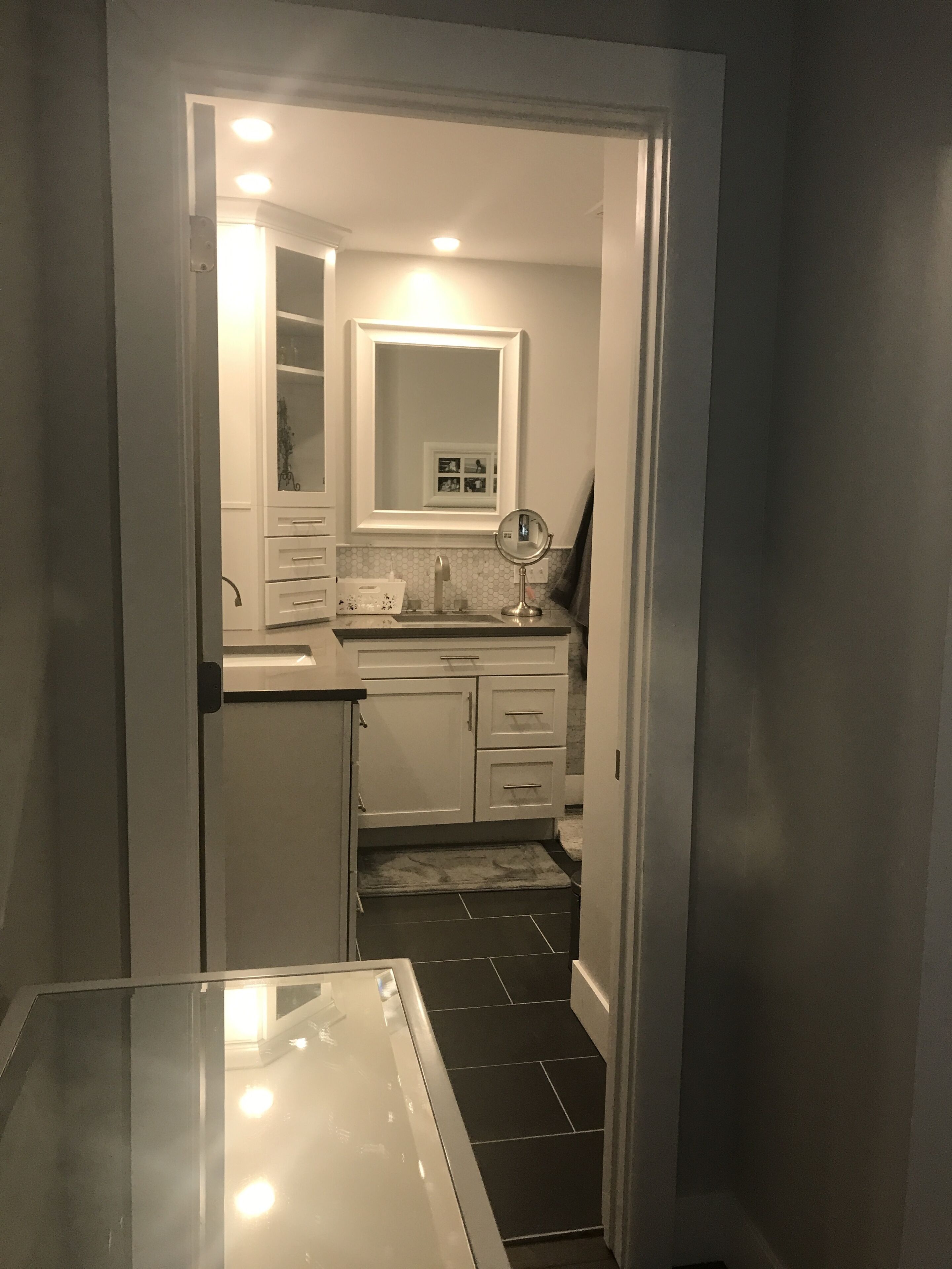 A compact bathroom with a mirror, sink, and cabinets.