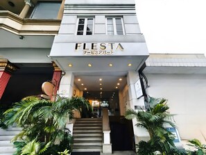 The exterior of a building with a sign reading "FLESTA" and a staircase leading to the entrance. - FLESTA Lê Thánh Tôn serviced apartment (Ho Chi Minh City)