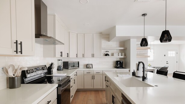 A modern kitchen with white cabinetry, a central island, stainless steel appliances, and pendant lighting. - Old Town Gem by Porter | Dog-Friendly Home w/Heated Pool and Arcade Games (Scottsdale)