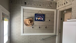 Un panneau mural avec une inscription « Bienvenue chez nous », un chapeau sur le thème du bord de mer et un ballon de football en guise de décoration.