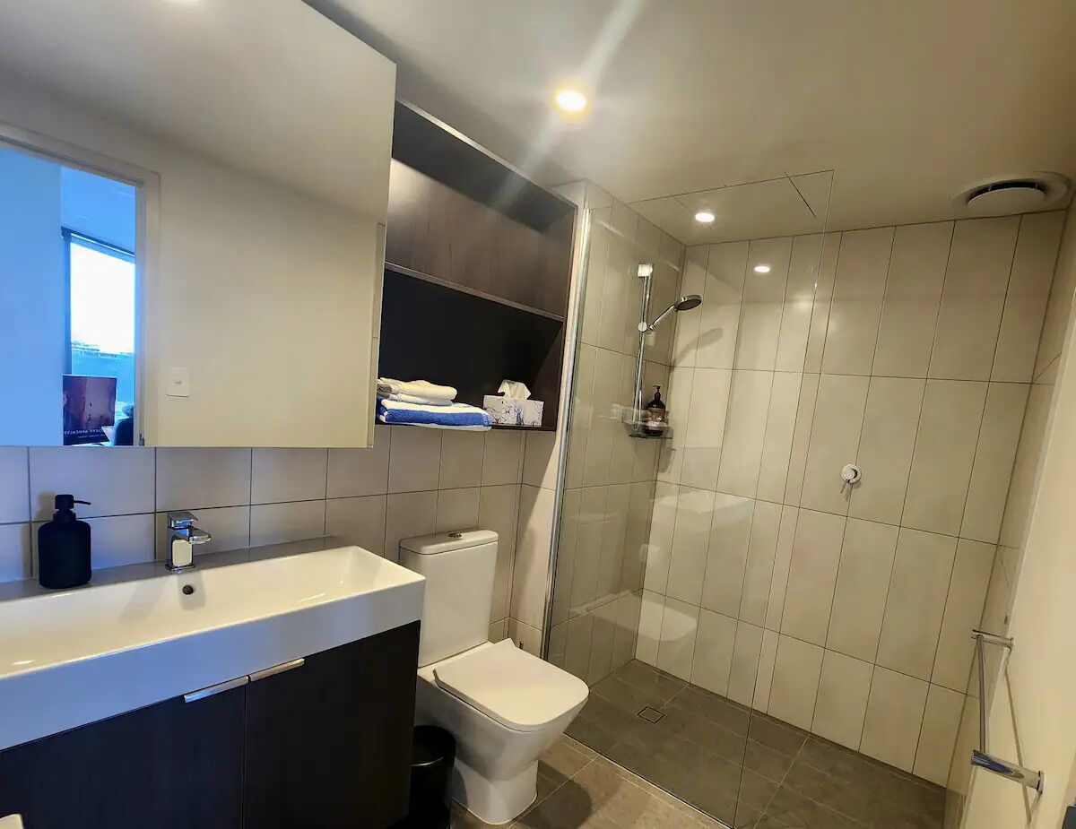 Une salle de bain moderne équipée d’une douche, de toilettes et d’un lavabo.