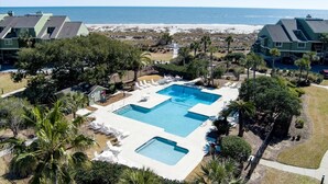 A resort with a large pool, palm trees, and a beach view. - New Listing! - 11A Mariners Walk - Ocean Front (Isle Of Palms)
