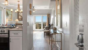 A kitchen with modern appliances, a dining area with a view, and a large window. - New Listing! - 11A Mariners Walk - Ocean Front (Isle Of Palms)