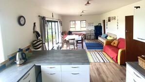 Un espacio habitable compacto con kitchenette, comedor y sofá.