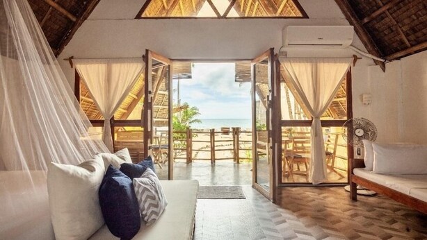 Una habitación con cama, sofá y vista a la playa.