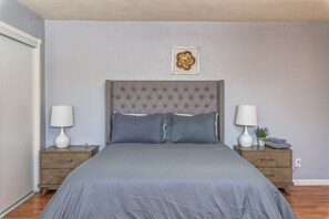 Cozy retreat with a large bed, two nightstands, and a framed artwork above.