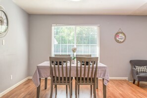 Enjoy meals in this cozy dining area with a table for two, a potted plant, and a beautiful view.