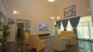 A spacious lobby with a high ceiling, a chandelier, a flat-screen TV, and comfortable seating. - Labev Hotel (Kumasi)