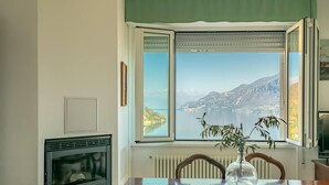 Un comedor con ventana panorámica que da a un lago y montañas.