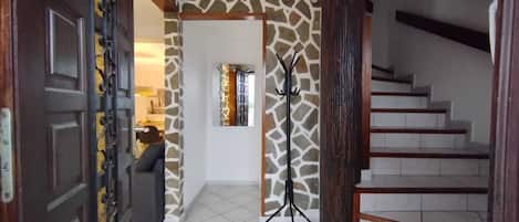 A staircase with a wooden handrail and a giraffe-patterned wall.
