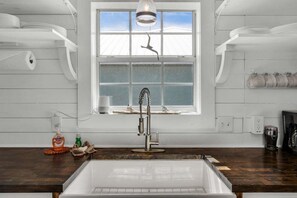 A kitchen with a large window, a modern faucet, and wooden countertops. - Summer Available! Private Pool, Private Home 6min walk to the Beach! (Panama City Beach)