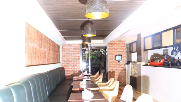 Un restaurant avec un mur en briques, un long comptoir et un espace où sont disposées des tables et des chaises.