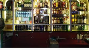 Un bar dont les étagères sont remplies de bouteilles et de canettes de toutes sortes.