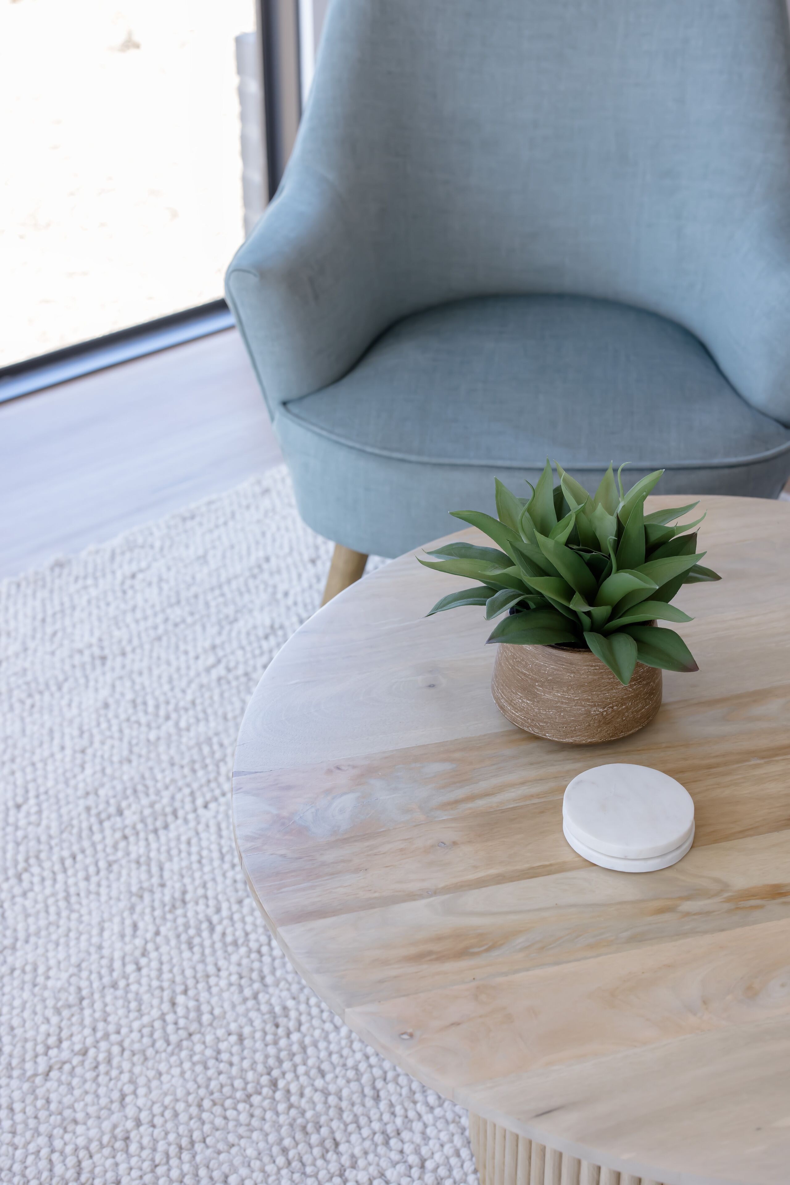 A round table with a potted plant and a white object on it.