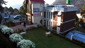 A hotel named "Hotel Apple.in" with a red roof and a sign indicating it offers vegetarian and non-vegetarian meals. - Hotel Apple Inn (Nainital)