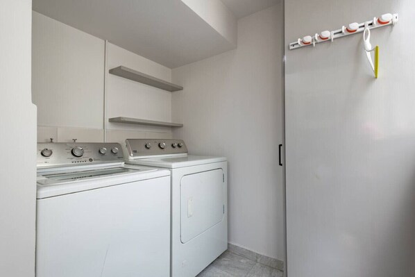 A laundry area with a washing machine, dryer, and a wall-mounted drying rack. - 2floors luxury apartment condesa (Ciudad de México)