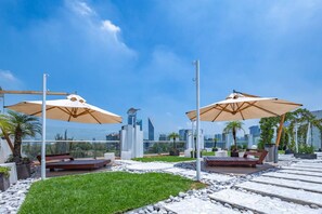 A rooftop terrace with outdoor seating, umbrellas, and a city skyline view. - 2floors luxury apartment condesa (Ciudad de México)