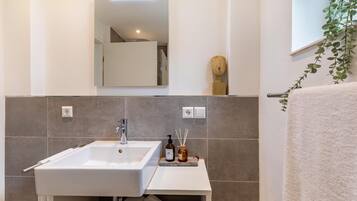 A bathroom with a white sink, mirror, and towel rack.