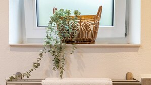 Een raam met een rieten mand en een hangplant.
