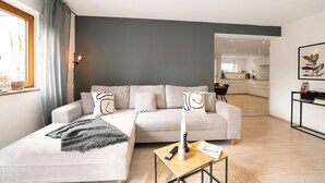 A modern living room with a sofa, a coffee table, and a remote control. - Apartment 'Casa Schneck' with Private Terrace and Wi-Fi (Longkamp)