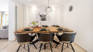 A dining area with a wooden table, black chairs, and a bull-themed artwork on the wall. - Apartment 'Casa Schneck' with Private Terrace and Wi-Fi (Longkamp)