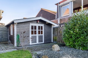 Ein Wohnhaus mit Garage, Holzzaun und gepflegtem Garten.