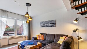 A modern living room with a sofa, a coffee table, a floor lamp, and a painting on the wall.
